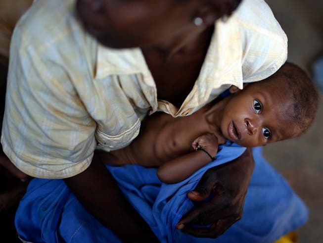 Eine Mutter wartet mit ihrem unterernährten Baby in einer Gesundheitsstation im zentralafrikanischen Bangui - die Hungersituation in der Zentralafrikanischen Republik wird im Welthungerindex als «gravierend» eingestuft. (Bild: KEYSTONE/AP/JEROME DELAY)