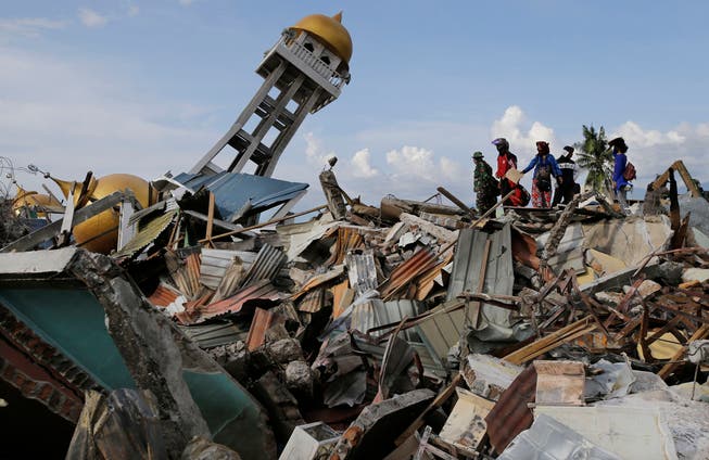 Ein Minarett ragt aus den Trümmern einer eingestürzten Moschee in der vom Tsunami zerstörten Stadt Palu auf der indonesischen Insel Sulawesi. (Bild: Aaron Favila/AP)