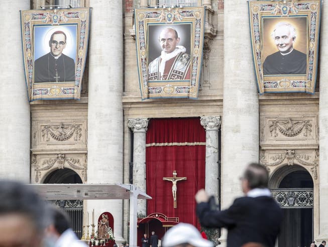 Während der Heiligsprechung von Erzbischof Oscar Romero (l.), Paul VI. (M.) und eines weiteren Seligen prangen deren Grossporträts an der Fassade des Petersdoms. (Bild: KEYSTONE/EPA ANSA/GIUSEPPE LAMI)
