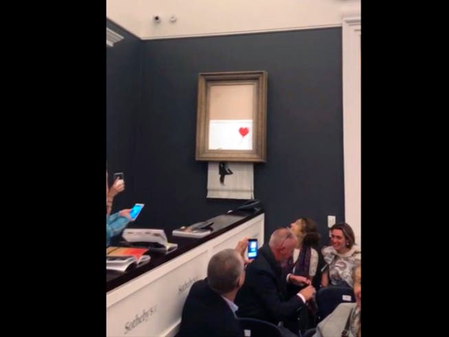 Der Künstler Banksy meldet sich am Mittwoch in einer Videobotschaft zu seiner spektakulären Aktion mit einem geschredderten Kunstwerk zu Wort. (Bild: KEYSTONE/AP Pierre Koukjian)