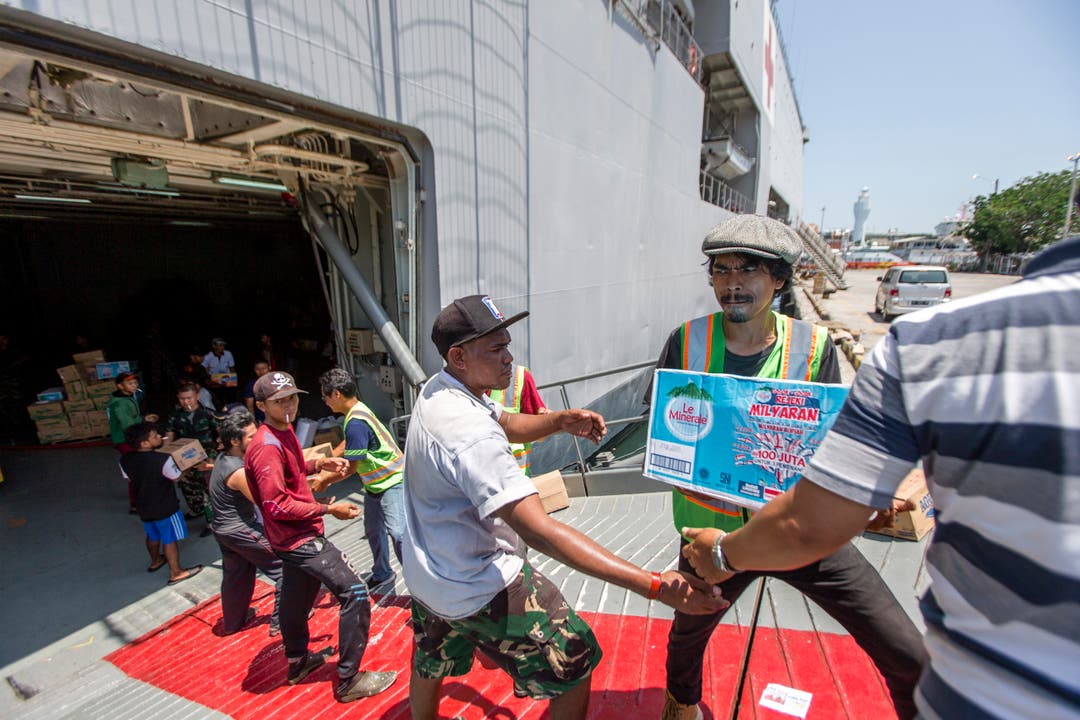 Helfer und Mitarbeiter des Militärs bringen Hilfsgüter an Land. (EPA/MADE NAGI)