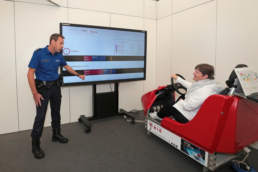 Brigitte Meier aus Wädenswil testet ihre Fahrfähigkeit unter simuliertem Alkoholeinfluss, beobachtet von Polizist Harald Hirzel. (Bild: Roger Zbinden (Zug, 20. Oktober 2018))