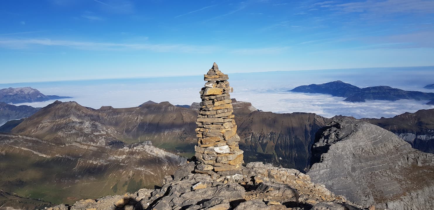 Sonnige, herbstliche Aussicht des "Steinmanndli" vom Gipfel des Uri - Rotstock auf die Zentralschweiz, die im dichten Nebel liegt. (Bild: Dorothe Gut (Uri Rotstock, 21. Oktober 2018))