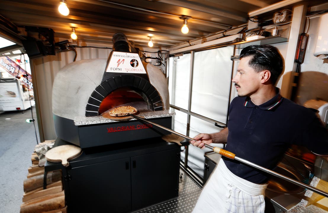 Pizzaiolo Luli Selimi von Woody Pizza schmeisst eine Margaritha in den Ofen.(Bild: Stefan Kaiser (Zug, 23.Oktober 2018))