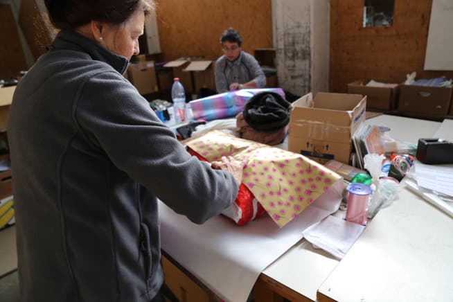 Ehrenamtliche Helfer verpacken Teddybären, Kleidung oder auch Schulmaterial für Weihnachten. (Bild: Ines Biedenkapp)