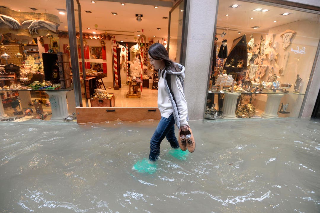 Eine Frau schreitet durch eine überflutete Strasse in Venedig. Gemäss den Behörden stehen 70 Prozent des historischen Zentrums der Stadt unter Wasser. (Bild: Andrea Merola/Keystone (29. Oktober 2019))