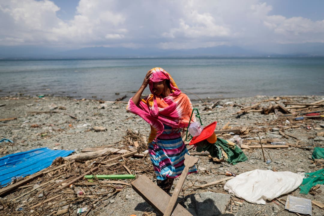 Eine Bewohnerin von Zentral-Sulawesi auf der Suche nach brauchbaren Materialien am Strand. Kasma floh bergaufwärts mit ihren zwei Kindern vor dem Tsunami, der ihr Haus zerstörte. (Bild: EPA/MAST IRHAM)