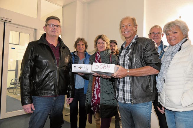 Mark Ullmer übergibt Herbert Fischer von der Staatskanzlei (links) die Kiste mit den Unterschriften. (Bild: Charly Keiser (Zug, 30. Oktober 2018))
