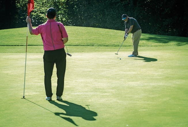 Zwei Golfer beim Putten auf dem Green. Beim Benefizturnier herrschte ideales Golfwetter. (Bild: Reto Martin)