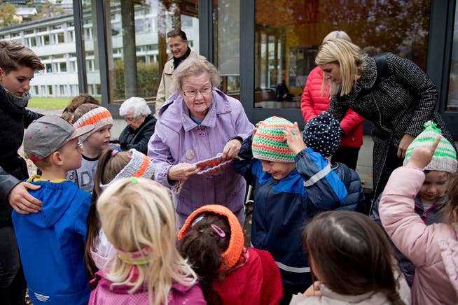 Irene Brehm (Mitte) übergibt Stricksachen an Kindergärtler. (Bild: Corinne Glanzmann (Sarnen, 30. Oktober 2018))