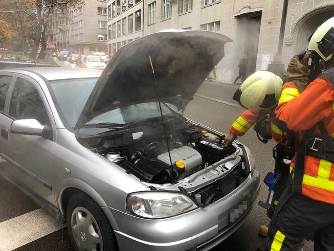 Angehörige der Berufsfeuerwehr St.Gallen begutachten das Auto, dessen Motor am Montag in der Tiefgarage am Oberen Graben in St.Gallen Feuer gefangen hatte. (Bild: Stadtpolizei St.Gallen - 19. November 2018)