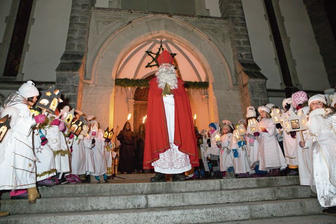 Der Samichlaus präsentiert sich mit Begleitern vor der Pfarrkirche von Ennetbürgen. (Bild: André A. Niederberger (2. Dezember 2017)))