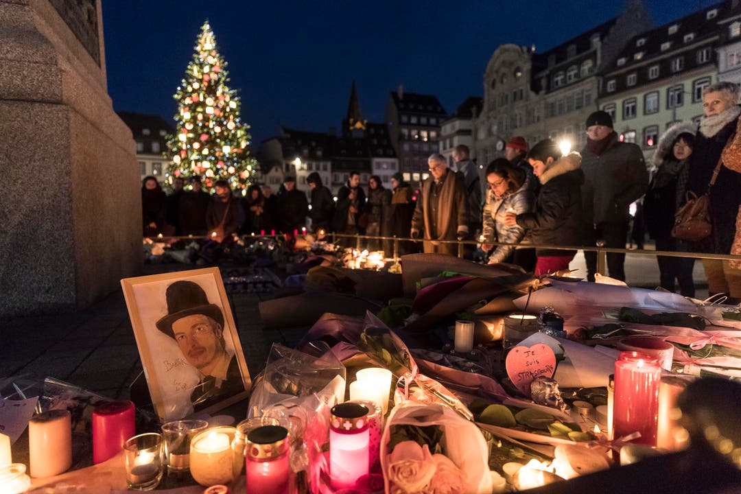 Menschen legen Blumen und Kerzen nieder in Strassburg. (Bild: AP Photo/Jean-Francois Badias, Pool, 14. Dezember 2018)