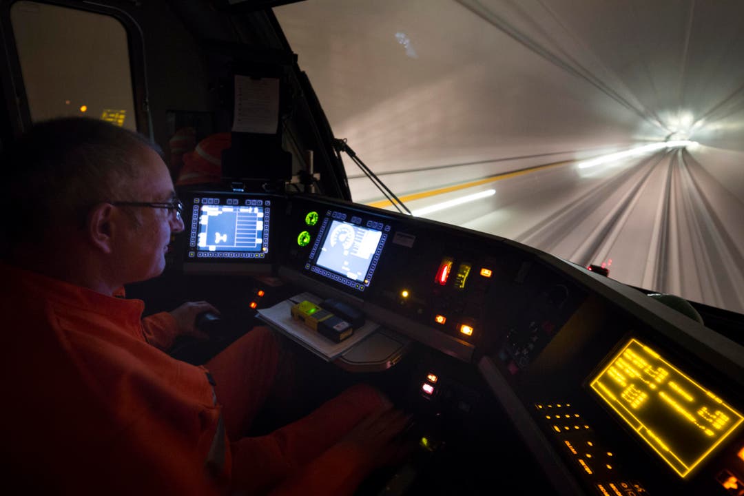 Er drückt den Hebel nach vorne: Der Lokführer im Cockpit des Testzugs während einer Fahrt durch die Weströhre von Erstfeld nach Biasca. (Bild: KEYSTONE/GAETAN BALLY)