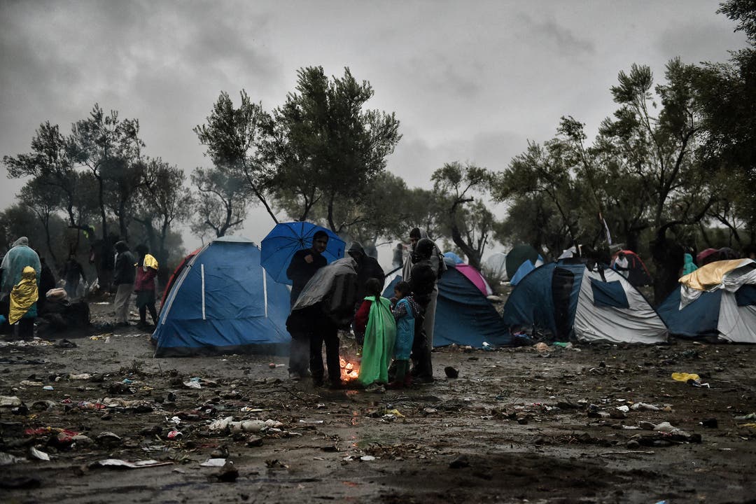 Flüchtlinge warten im starken Regen ausserhalb von Moria. (Bild: AFP/Aris Messinis)