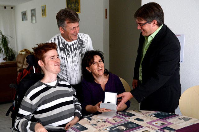 Benjamin Gutic und seine Eltern Bego und Sibylle erhalten von Redaktor Christian Bertschi den Preis für die «Unbekannten Helden». (Bild: Nadia Schärli / Neue LZ)