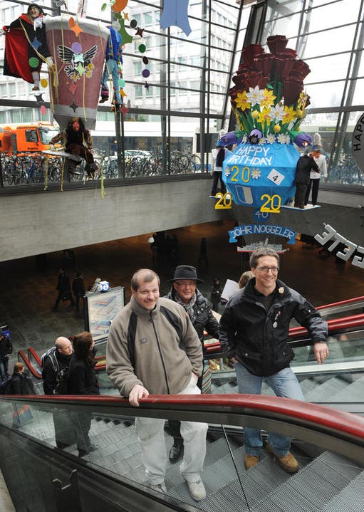 Werner Luternauer, Werner Rast und Markus Haag (von links) mit zwei Sujets der Fasnachtsausstellung im Bahnhof. (Bild: Boris Bürgisser/Neue LZ)