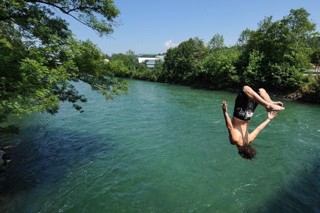 Mario Disler springt von der Rathausen-Brücke in die Reuss. (Bild Boris Bürgisser/Neue LZ)