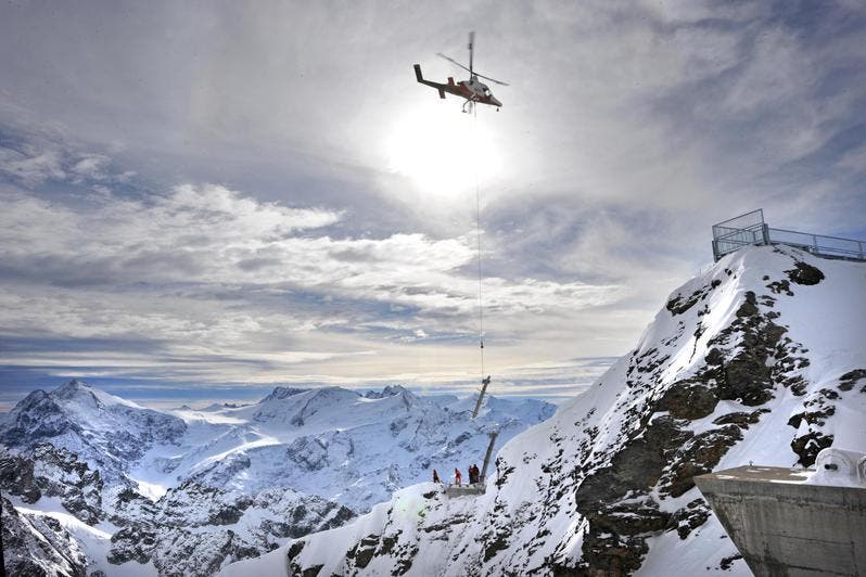 Ein Helikopter liefert die Pfeiler an. (Bild: Eveline Beerkircher/Neue LZ)