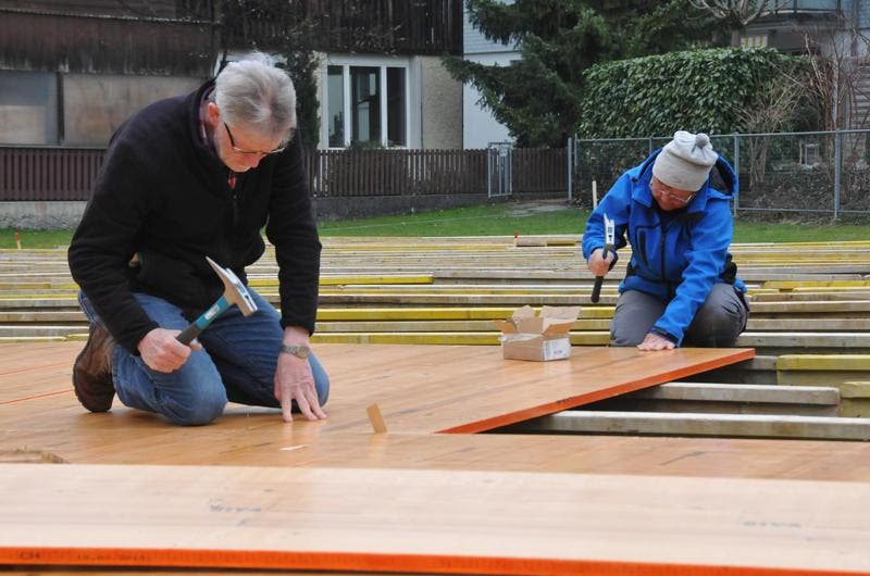 Koni Lüönd (links) und Roswitha Kaplick bauen den Holzboden zusammen. (Bild: Matthias Piazza / Neue NZ)