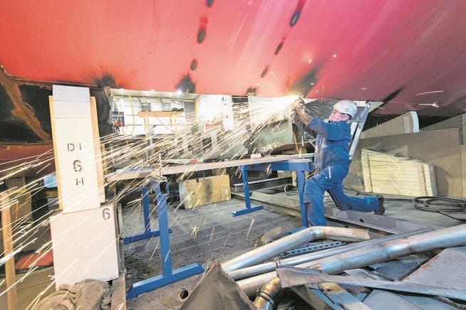 Ein Angestellter der Shiptec AG in der Luzerner Werft bei Schleifarbeiten am Rumpf des MS Diamant. (Bild: Eveline Beerkircher (Luzern, 22. Februar 2018))
