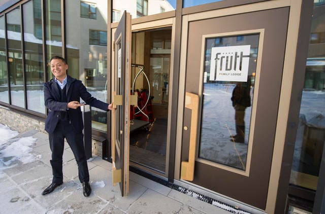 Der chinesische Investor Yunfeng Gao öffnet die Tür des neuen Ferien-Resorts Frutt Family Lodge. (Bild: Keystone / Urs Flüeler)