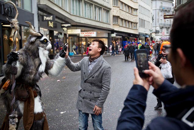 Ein chinesischer Tourist freut sich über ein Sujet der Luzerner Fasnacht. (Bild: Manuela Jans / Neue LZ)