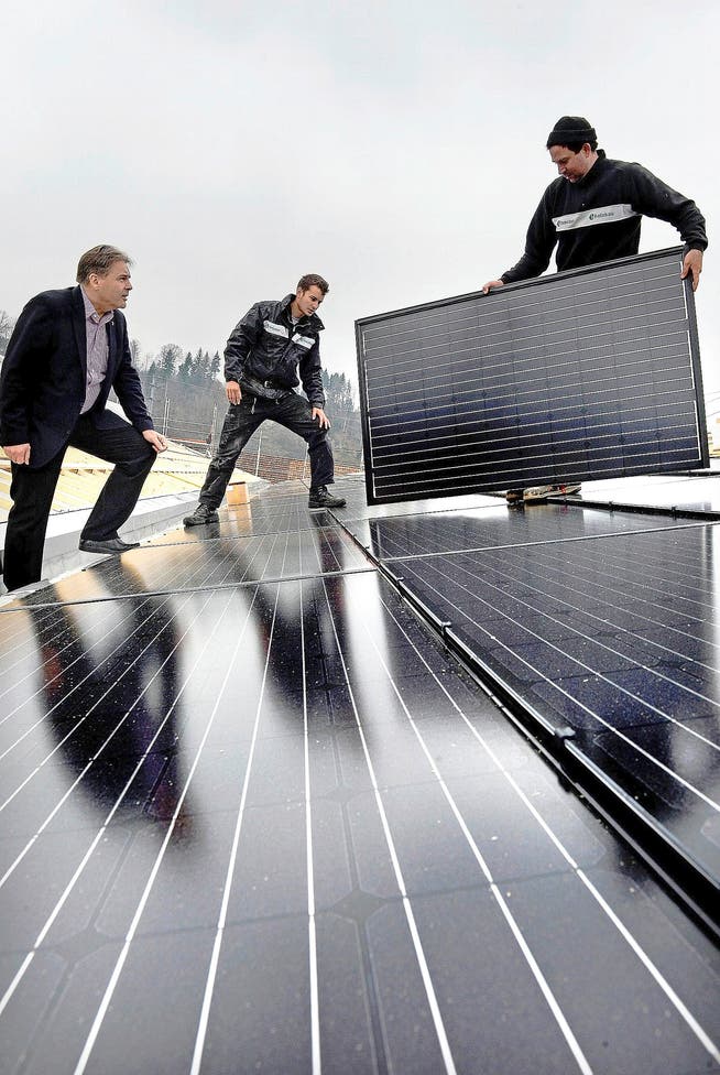 Rolf Hunkeler, Chef der 1a Hunkeler (links), bei der Installation der Fotovoltaik-Anlage auf dem Firmensitz in Ebikon. (Bild: Nadia Schärli)
