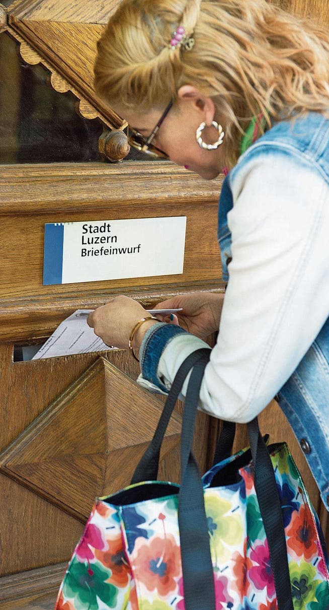Eine Luzernerin wirft ihr Stimmcouvert in den Briefkasten beim Stadthaus in Luzern. (Bild: Eveline Beerkircher (17. Mai 2017))