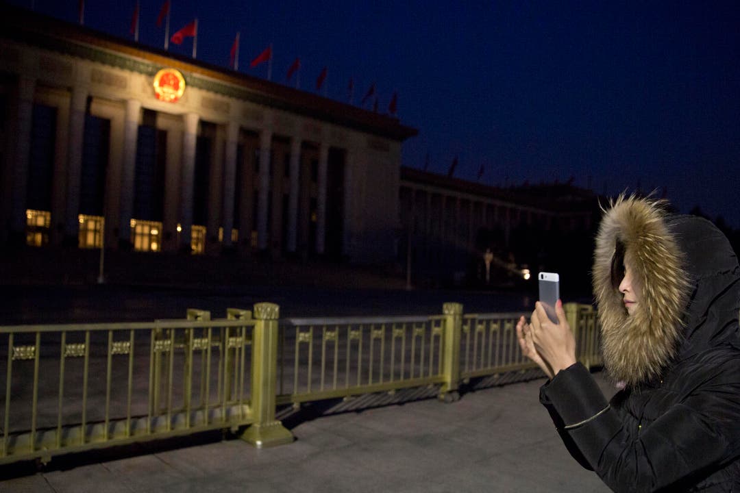 Eine Chinesin macht mit ihrem Smartphone ein Bild von der Great Hall of the People. (Bild: Ng Han Guan)