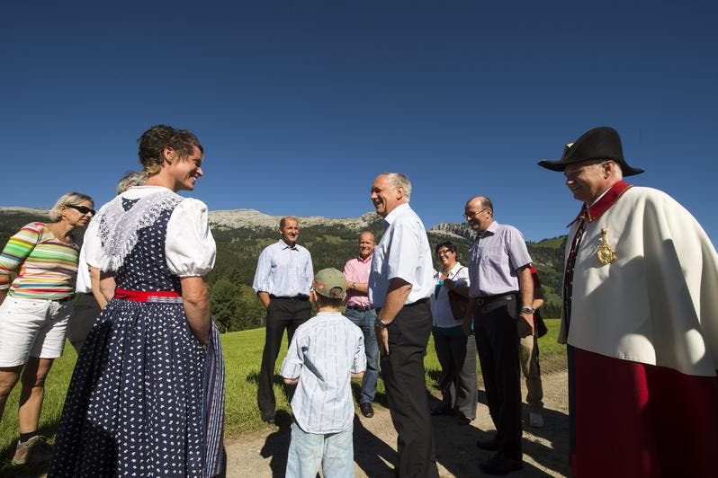 Bundesrat Johann Schneider- Ammann besucht am 1. August den Birkenhof in Sörenberg, um am 1. Augustbrunch teilzunehmen. Die Familie Schnider begrüsst den Bundesrat vor der Kulisse des Schratten. (Bild: Keystone)