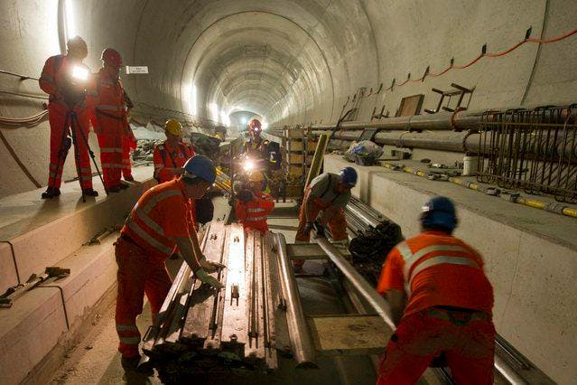 Arbeiter bewerkstelligen den Einbau der Bahntechnik im Gotthard-Basistunnel. (Bild: Keystone)