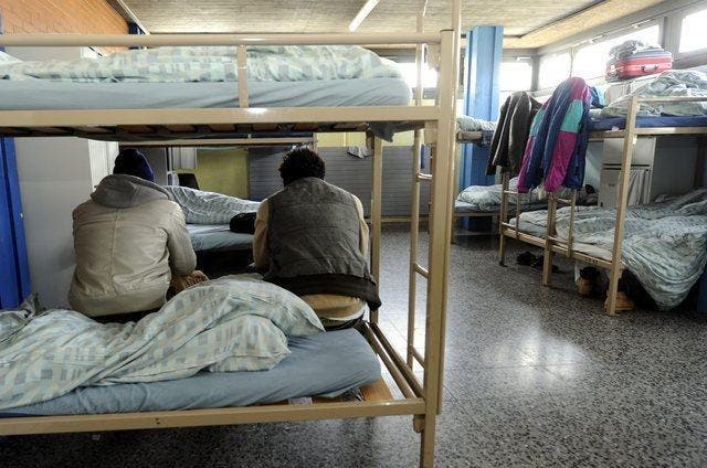 Bewohner eines Asylheims sitzen auf ihren Betten. (Bild: Keystone)
