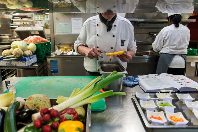 Ein Koch rüstet in einer Hotelküche Gemüse. (Symbolbild: Christian Beutler/Keystone)