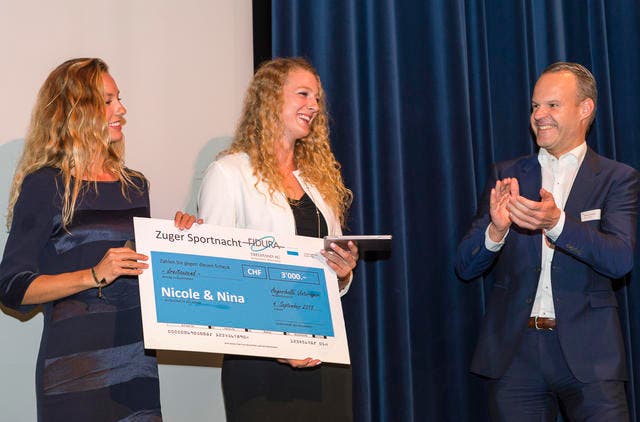 Nina Betschart, links, und Nicole Eiholzer nehmen den Scheck über 3000 Franken von Regierungsrat Stephan Schleiss entgegen. (Bild: PD)