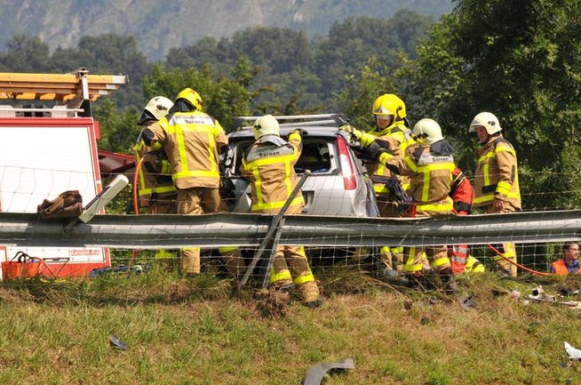 Rettungskräfte bemühen um die Insassen eines am Unfall beteiligten Fahrzeuges. (Bild: Robert Hess / Neue OZ)