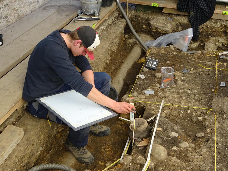 Ein Mitarbeiter der Kantonsarchäologie bei der Dokumentation eines Urnengrabs. (Bild: PD)