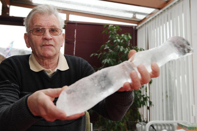 Josef Renggli aus Aesch zeigt einen Eisbrocken, der auf sein Hausdach gefallen sein soll. (Bild Boris Bürgisser/Neue LZ)