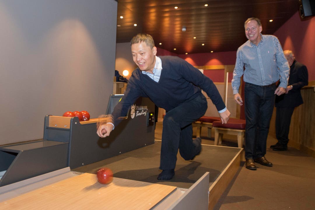 Yunfeng Gao zeigt, wie Bowling gespielt wird. Rechts im Bild: Toni Eberli, Verwaltungsratspräsident der Eberli Sarnen AG. (Bild: Keystone / Urs Flüeler)