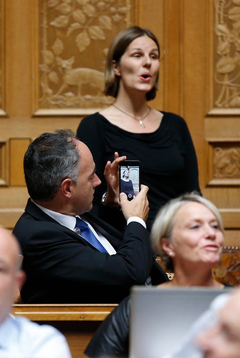 Der CVP-Parteipräsident Christophe Darbellay filmt mit seinem Smartphone während der Gesangseinlage. (Bild: Peter Klaunzer / Keystone)