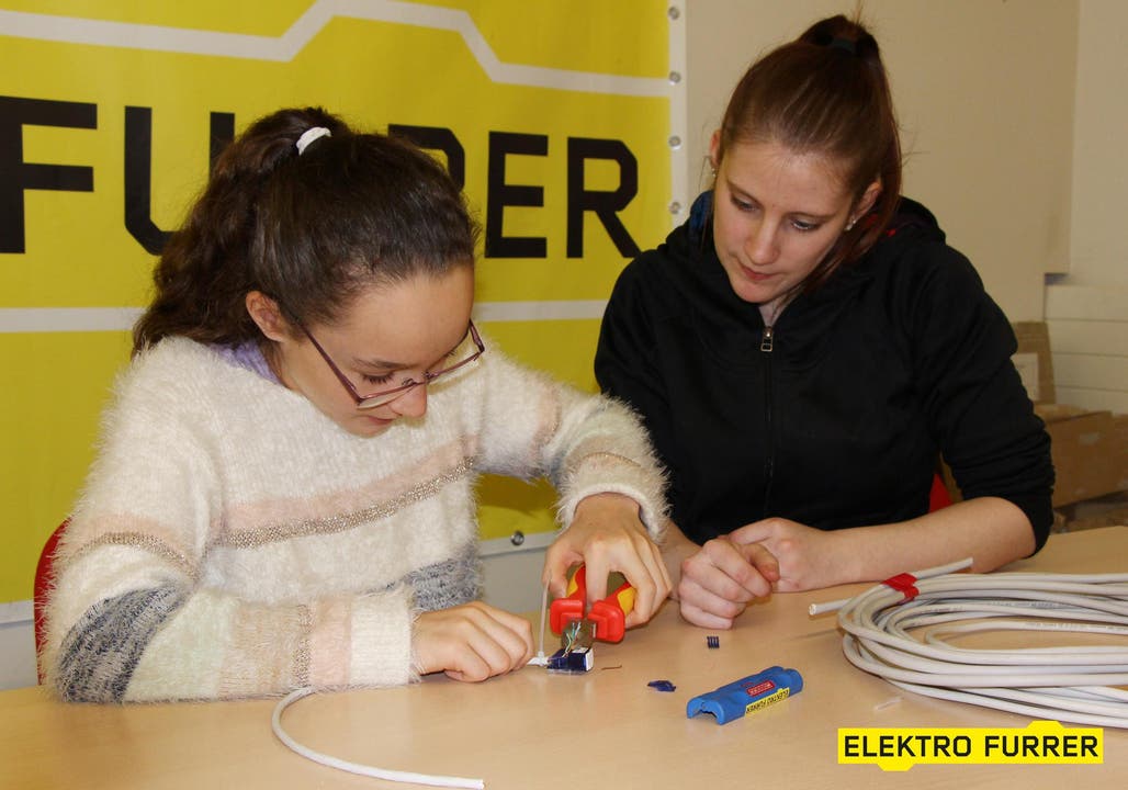 Elektro Furrer AG: Eveline Imfeld, Lernende Telematikerin hilft Nathalie beim Anschliessen der Kabel. (Bild: Cornel von Wyl)