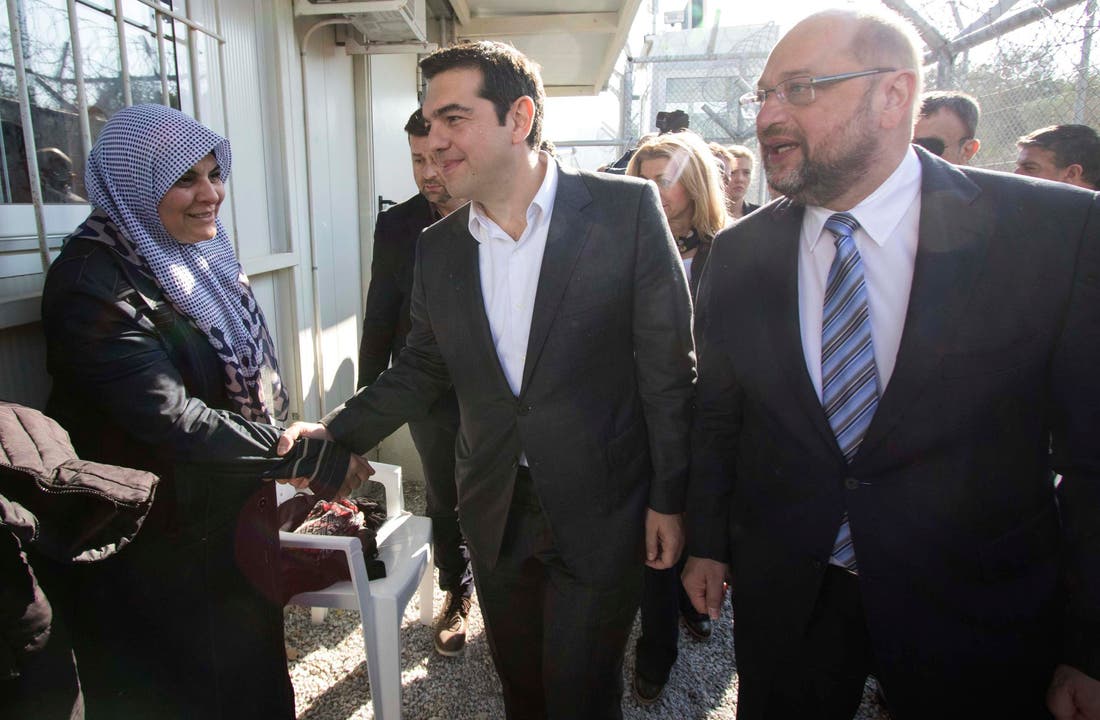 Der griechische Premierminister Alexis Tsipras, Mitte, und EU-Parlamentspräsident Martin Schulz, begrüssen eine Frau im Flüchtlingslager in Moria. (Bild: EPA/Andrea Bonetti)