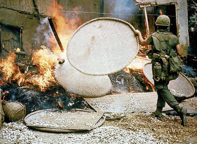 Ein US-Soldat schürt das Feuer an einem Haus in My Lai. (Bild: Ronald S. Haeberle/Getty (My Lai, 16. März 1968))