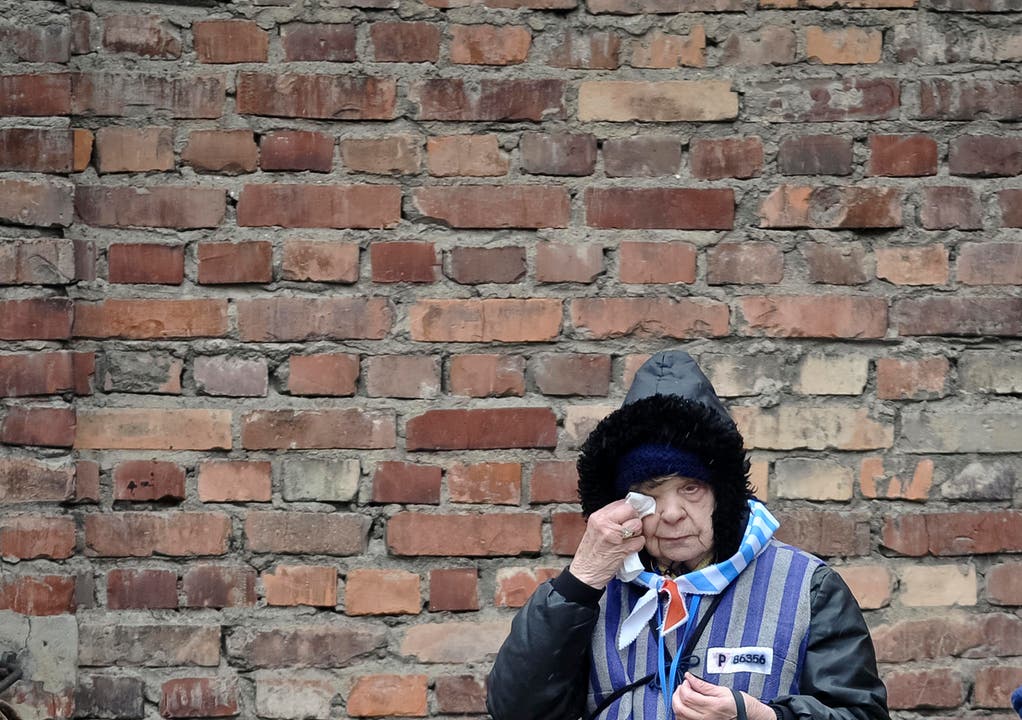 Eine Überlebende wischt sich Tränen aus den Augen ausserhalb der Mauern von Auschwitz. (Bild: Keystone)