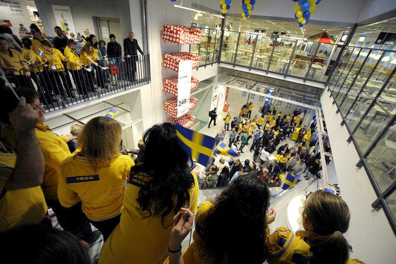 Die Kundinnen und Kunden unmittelbar nach dem Einlass in den neuen IKEA. Sie werden mit Schweden-Fähnchen von den Mitarbeiterinnen und Mitarbeitern begrüsst. (Bild: Pius Amrein / Neue LZ)