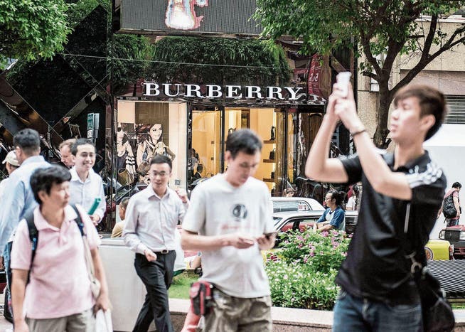 Passanten vor einem Burberry-Shop an einer Einkaufsstrasse in Hongkong. (Bild: Xaume Olleros/Getty (10. August 2015))