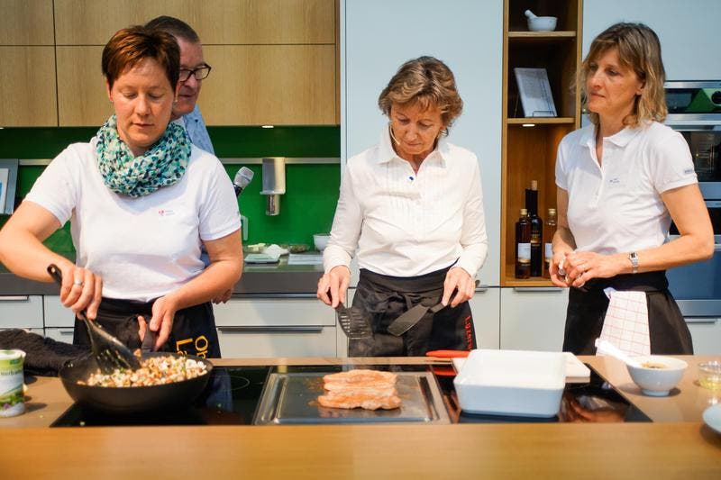 In der Kocharena schwingen Bäuerinnen die Kelle. Kantonsratspräsidentin Irene Keller (mitte) sowie die Bäuerinnen Priska Röthlin (links) und Heidi Schmid. (Bild: Roger Grütter / Neue LZ)