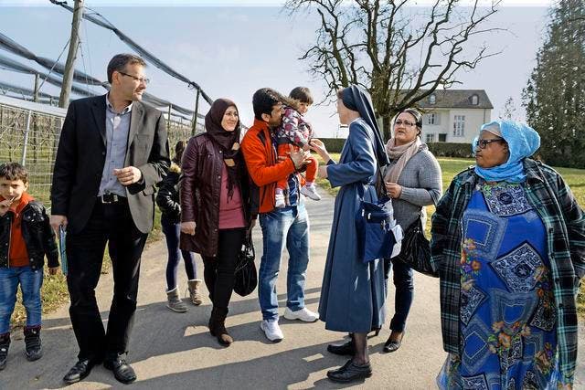 Schwester Nadia vom Kloster Baldegg zusammen mit syrischen Flüchtlingen, die seit Januar im Gästehaus (im Hintergrund) wohnen. Das Bild wurde im März aufgenommen. (Bild Nadia Schärli)