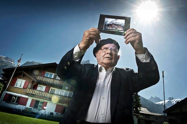 Walter Zimmermann (86) betrachtet vor seinem Ferienheim St. Raphael in Engelberg ein Dia des 50-jährigen Hauses. (Bild Pius Amrein)