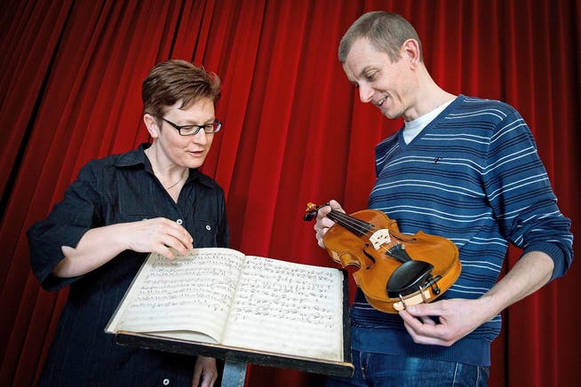 Musikerin Evi Güdel-Tanner und Adrian Steger, Leiter der Musikinstrumentensammlung Willisau, mit einem der kürzlich gefundenen Notenbücher und einer Geige. Beide Objekte stammen aus dem 19. Jahrhundert. (Bild Pius Amrein)